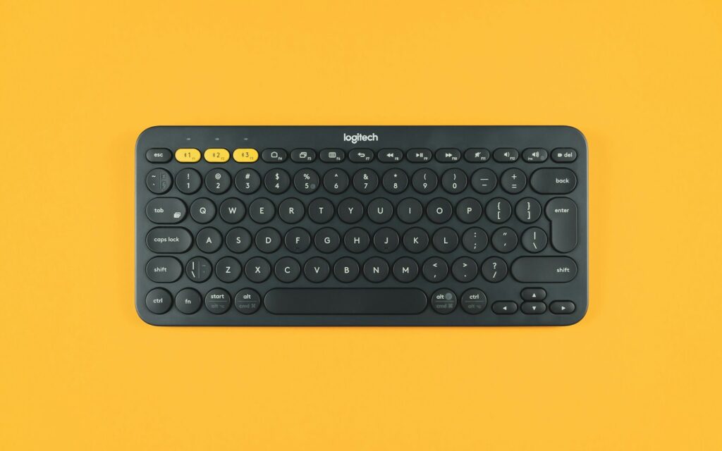 black logitech keyboard on orange surface