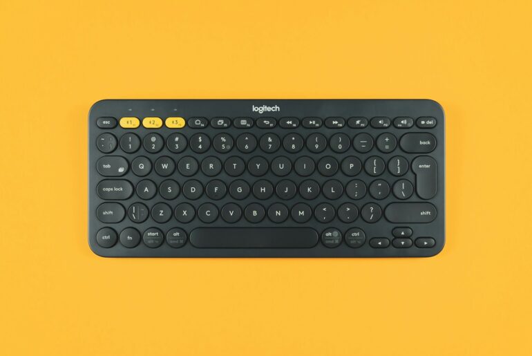 black logitech keyboard on orange surface